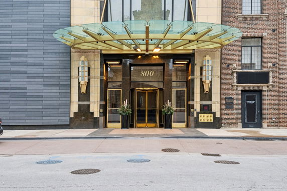 Front view of a building entrance with a glass canopy.