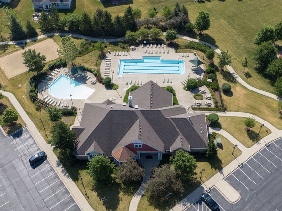 Aerial view of a building complex with two swimming pools and surrounding pathways.