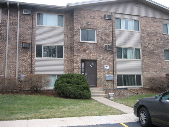 Front view of a multi-story brick building with several windows and a central entrance.