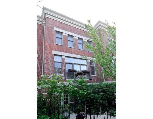 Front view of a multi-story brick building with multiple windows.