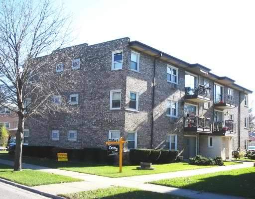 Front view of a three-story brick apartment building.