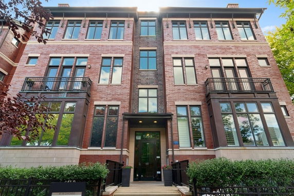 Front view of a multi-story brick building with large windows and balconies.