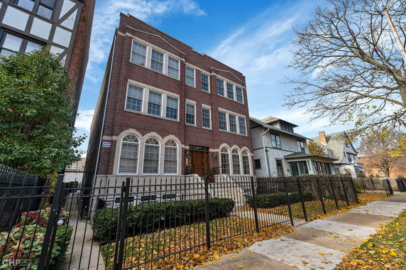Front view of a multi-story brick building with large windows and a central entrance.