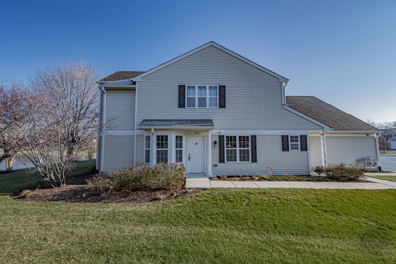 Front view of a two-story house with a pitched roof and white siding.