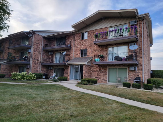 Front view of a multi-story apartment building with balconies.