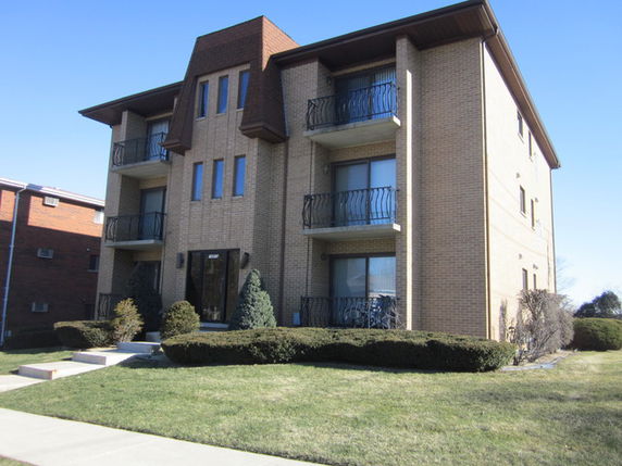 Front view of a multi-story building with balconies.