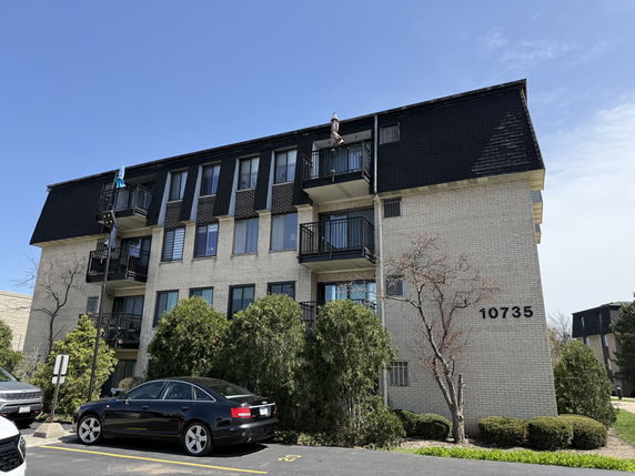 Front view of a three-story residential building with balconies.