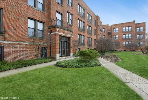 Front view of a brick multi-story building with several windows and a main entrance.