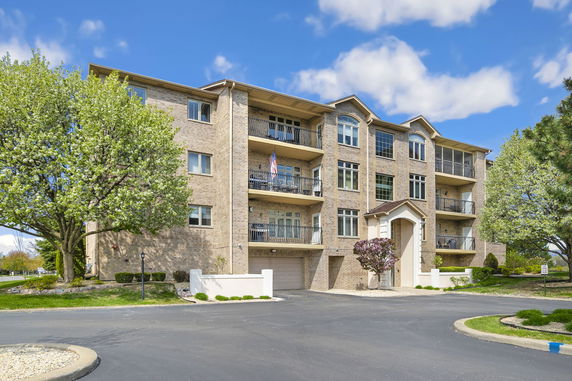 Front view of a multi-story residential building with balconies and brick exterior.