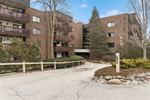 Front view of a multi-story brick apartment building with balconies.
