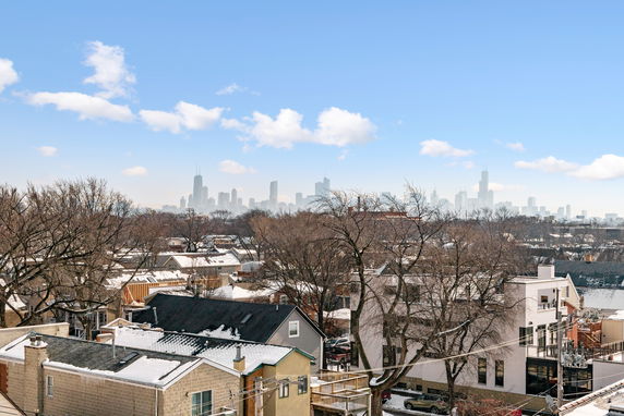 Panoramic view of a cityscape with buildings and snow-covered rooftops.