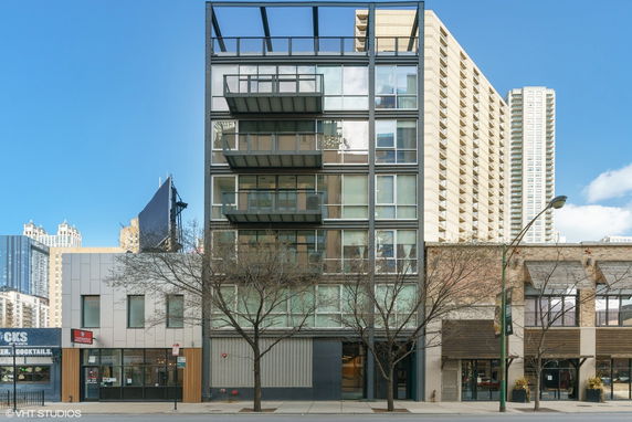 Front view of a multi-story modern building with glass and metal facade.