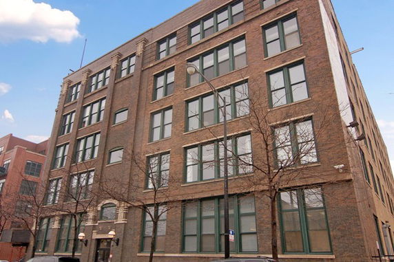 Front view of a multi-story brick building with numerous windows.