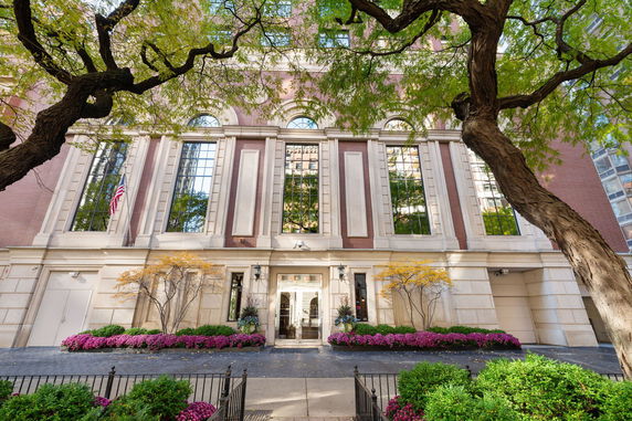 Front view of a multi-story building with large windows and decorative columns.