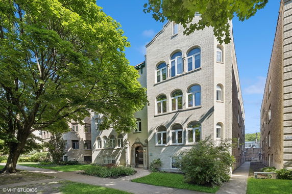 Front view of a multi-story brick building with arched windows.