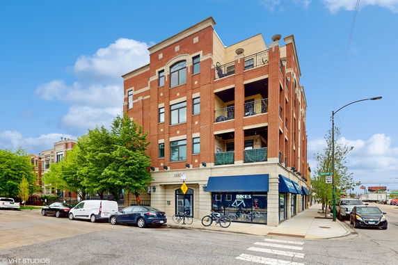 Front view of a multi-story brick building with retail store on the ground floor.