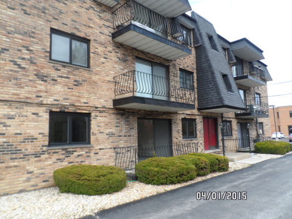 Front view of a multi-story apartment building with balconies.