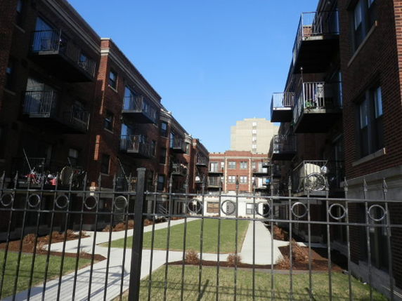 Front view of a multi-story apartment building with balconies.