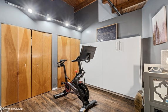 Indoor exercise area with a stationary bike and storage cabinets.