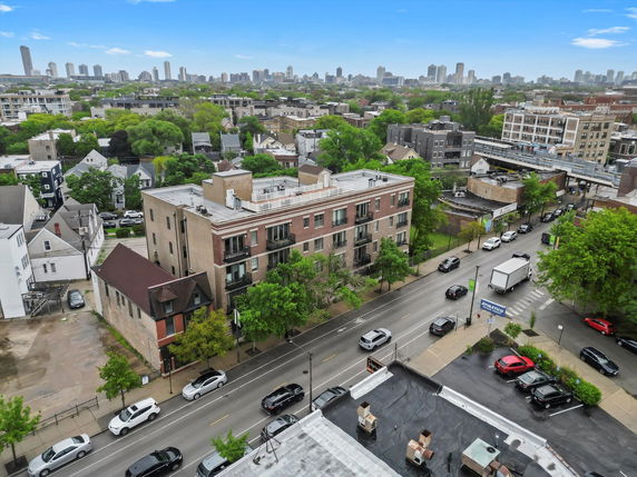 Panoramic view of an urban area with streets, buildings, and distant city skyline.
