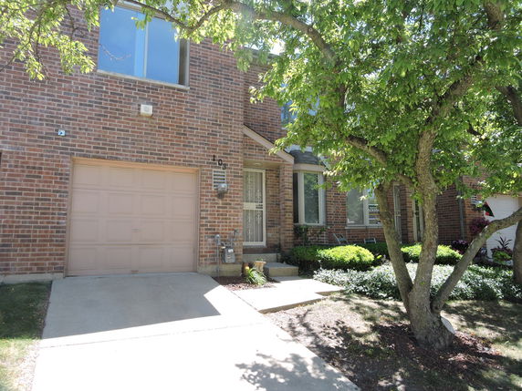 Front view of a brick house with a single-car garage.