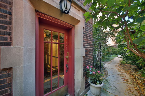 Front view of a building entrance with a red door and brick facade.