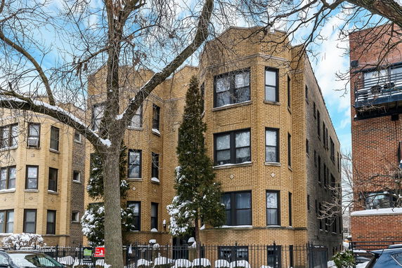 Front view of a multi-story brick apartment building.