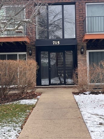 Front view of a multi-story building with a glass entrance marked 715.