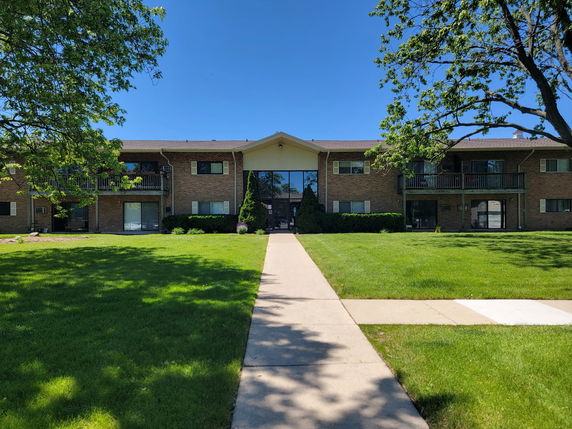 Front view of a two-story apartment building with balconies.