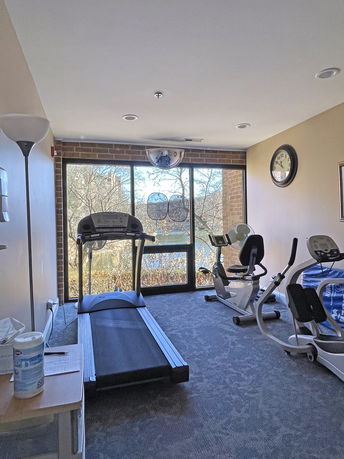 Indoor gym area with exercise equipment and a large window.