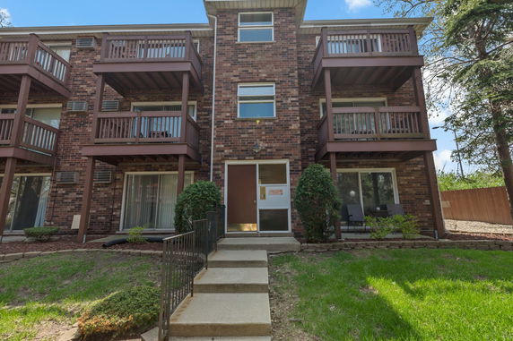 Front view of a multi-story apartment building with balconies.