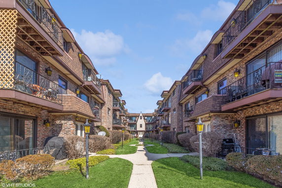 Front view of two adjacent multi-story residential buildings with balconies.