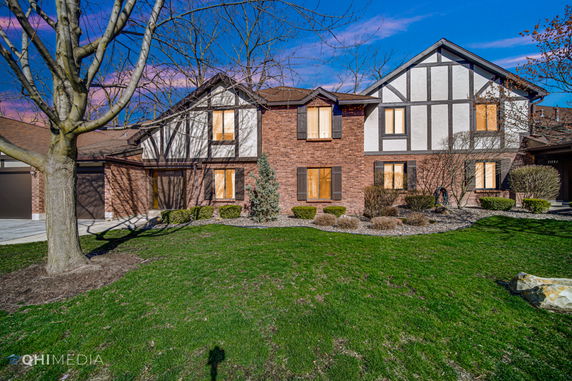 Front view of a two-story house with a combination of brick and siding exterior.