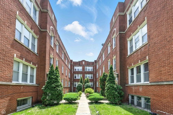 Front view of a red brick apartment building.
