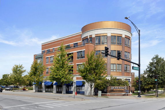 Front view of a multi-story brick building at a street intersection.
