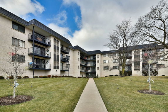 Front view of a multi-story apartment building with balconies.