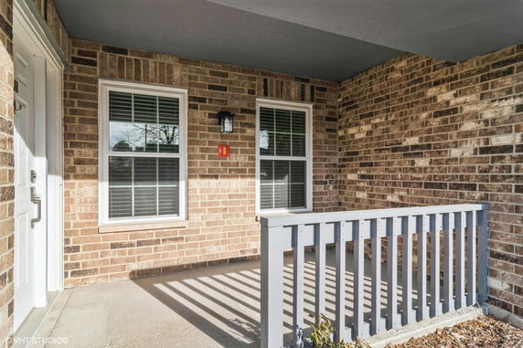 Front view of a house entrance with brick exterior and small porch.