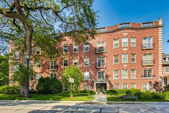 Front view of a multi-story brick building with numerous windows and a central entrance.