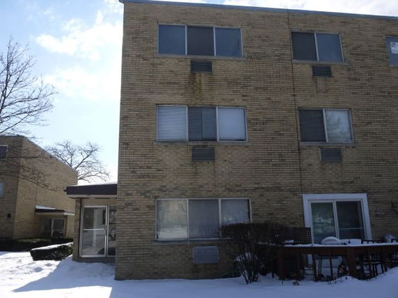 Front view of a three-story brick apartment building.