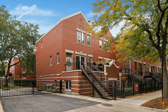 Front view of a multi-story brick building with exterior stairs.