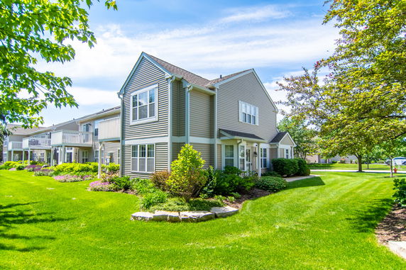 Front view of a two-story house with siding and landscaped yard.