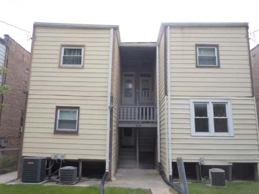 Front view of a two-story building with two separate sections and air conditioning units.