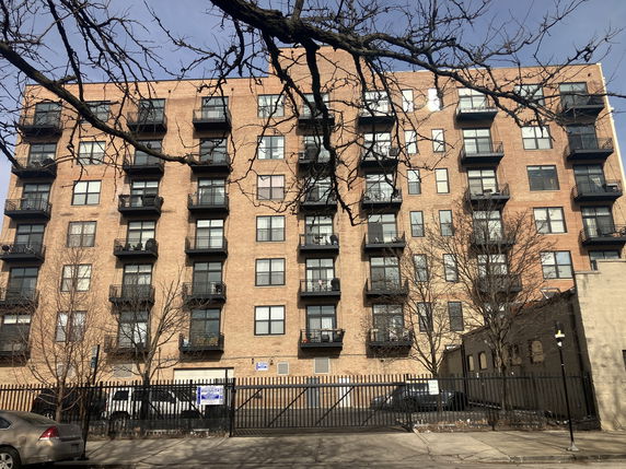Front view of a multi-story apartment building with balconies.