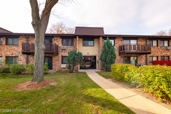 Front view of a two-story brick residential building with balconies.