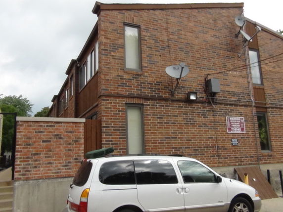Front view of a two-story brick building with satellite dishes.