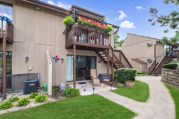 Front view of a two-story house with wooden exterior and balconies.