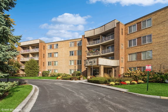 Front view of a multi-story apartment building with balconies.