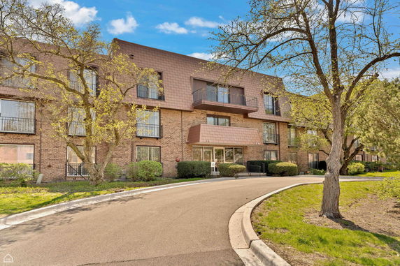 Front view of a multi-story brick building with balconies.