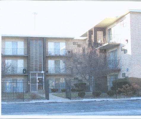 Front view of a three-story apartment building with balconies.