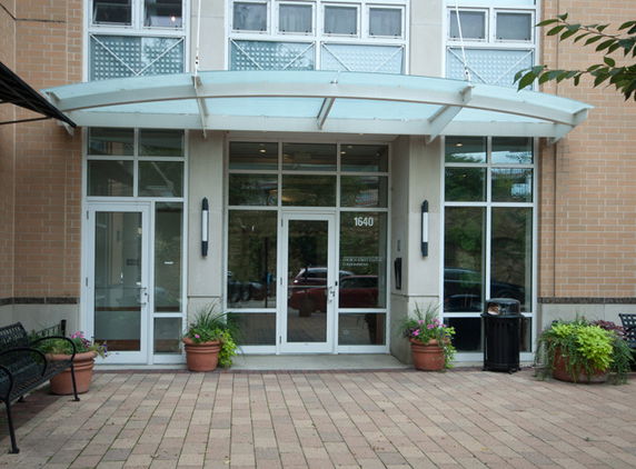 Front view of a modern building entrance with glass doors and awning.